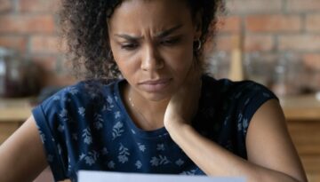 Close up unhappy African American woman reading letter, bad news