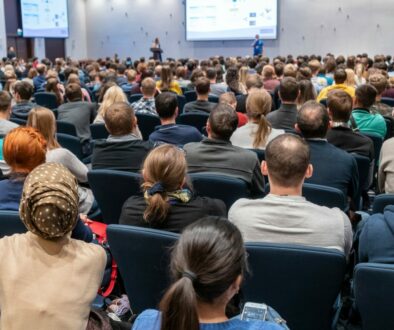 Image of a conference that takes place in a large conference roo