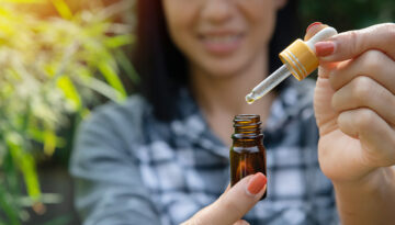 Glass bottle handle, CBD hemp oil. Farmers or researchers hold a