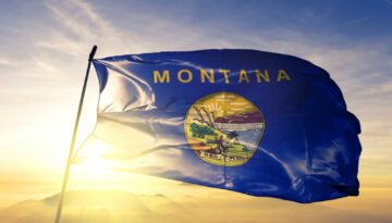 Montana state of United States flag waving on the top sunrise mist fog